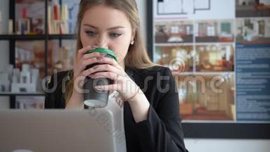 女<strong>室内设计师</strong>喝咖啡，在办公室里工作手提电脑